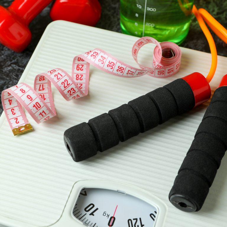 Weight loss concept on black smoky background, close up